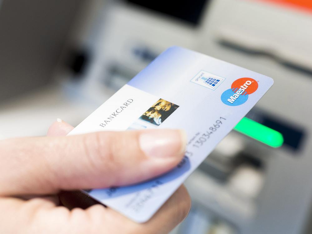 Kunde mit Bankkarte am ATM (Foto: Jochen Zick, action press / Bundesverband deutscher Banken; CC BY-ND 2.0)