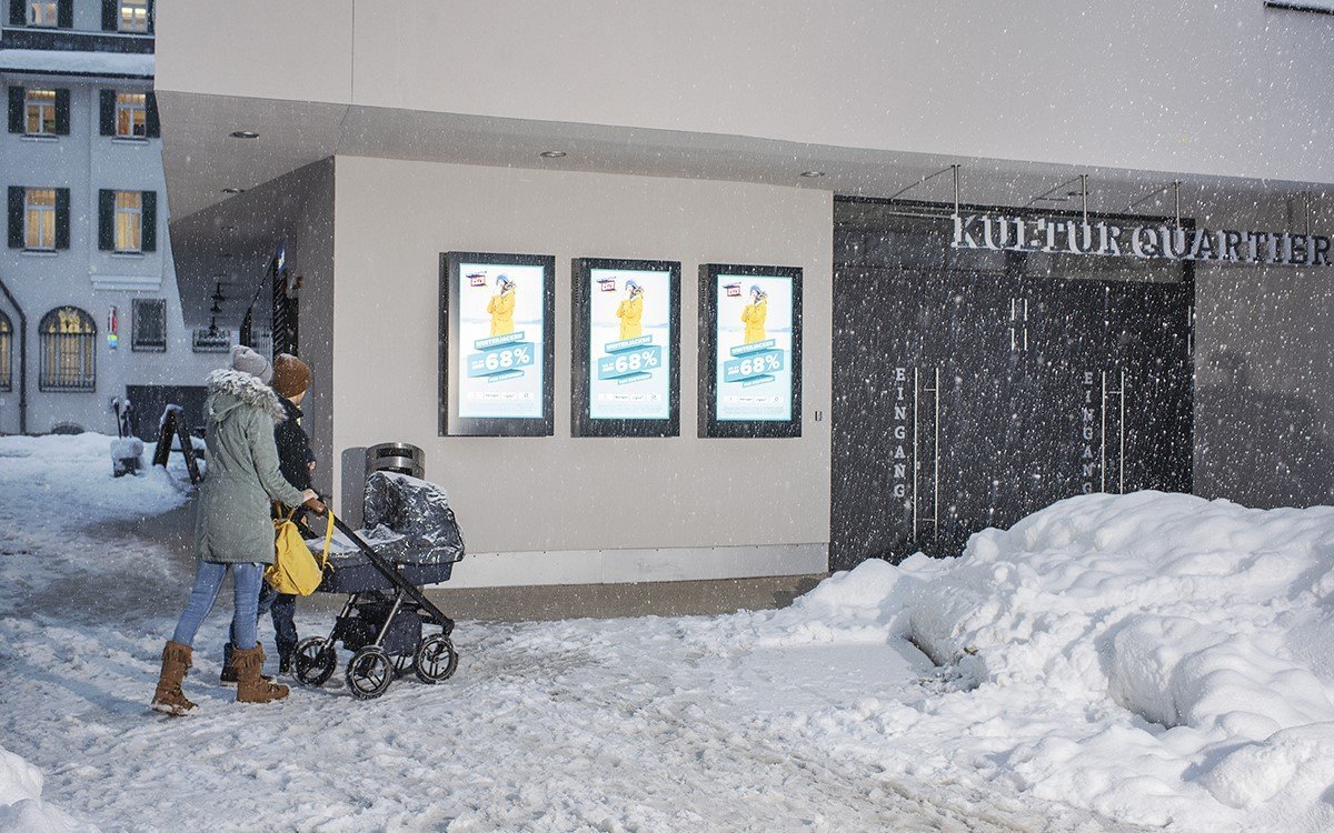 Werbung für Winterjacken bei Schnee auf Programmatic DooH-Displays von Peakmedia mit 'kompas' von dimedis (Foto: Peakmedia)