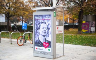 Eine der 10 Gewista/A1 Telefonzellen mit eingebautem DEFI und digitalen City Lights, auf denen auch die aktuelle Defi-Kampagne "Puls-Moment", kreiert von der Agentur Lumsden & Friends, läuft (Foto: Puls/H. Kellner)
