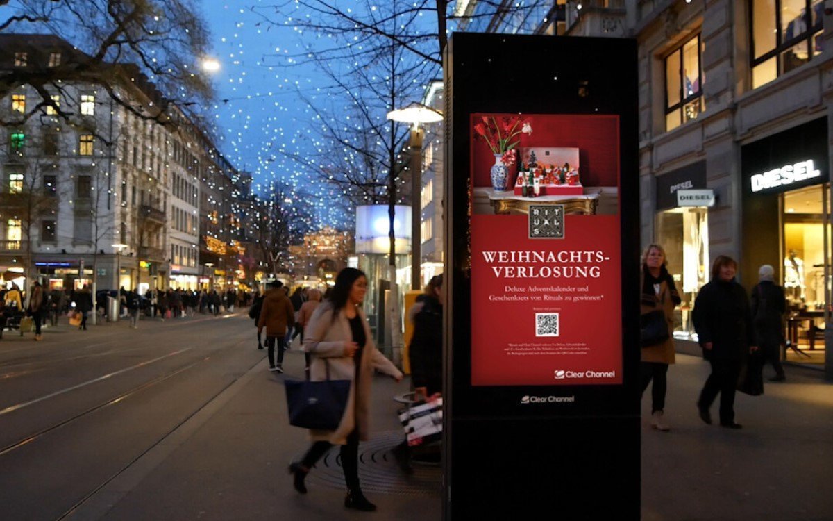 Via QR-Code können Passanten bei der Rituals-Kampagne zum Night-Shopping an einer Verlosung teilnehmen (Foto: Bildmontage, Hintergrund aus 2019, Clear Channel)
