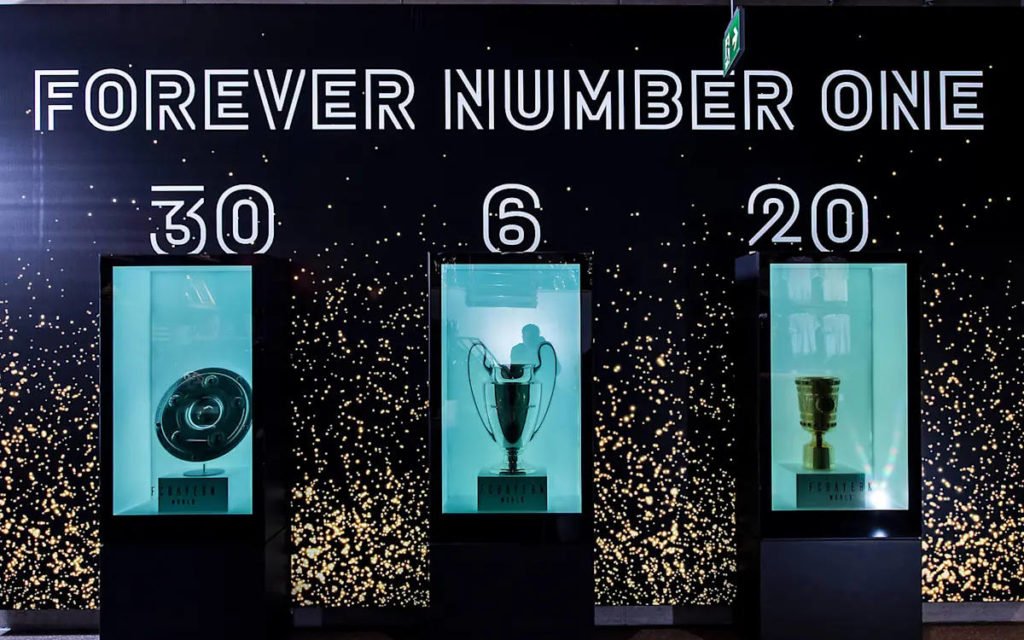 Die Triple Pokale 2020 des FC Bayern hinter transparenten Displays (Foto: FC Bayern)