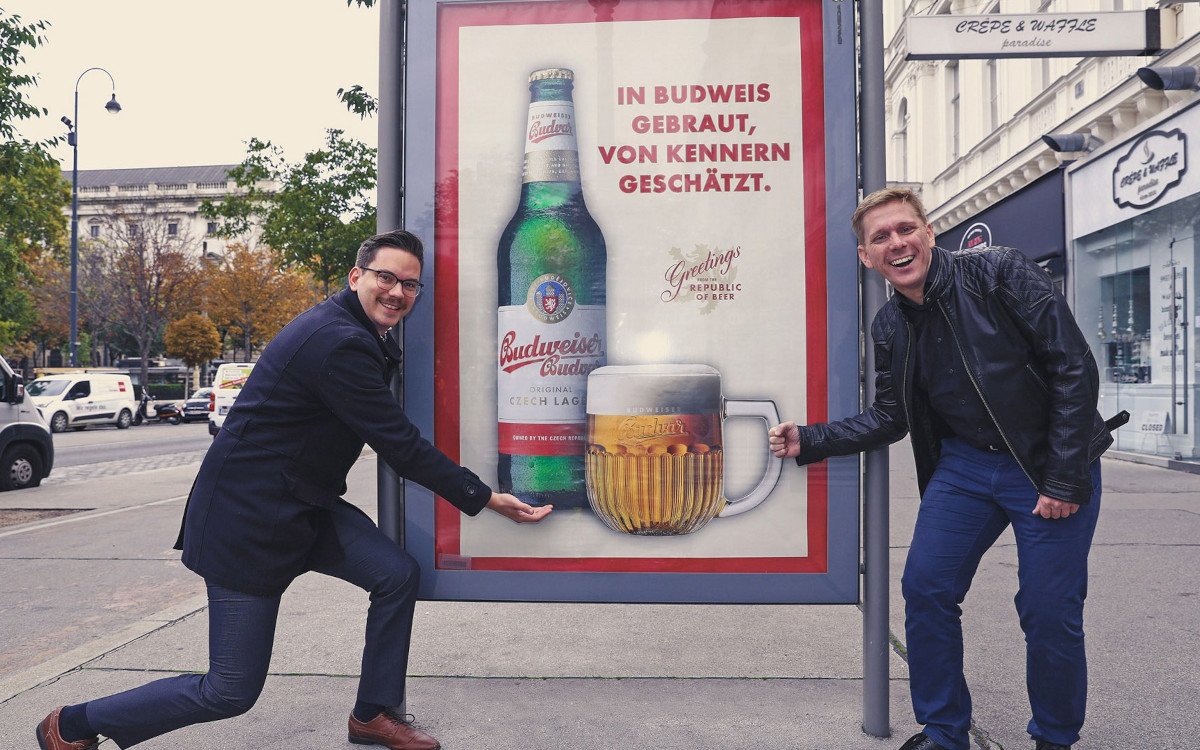 Von links: Laurin Wondra von Epamedia und Michael Kolarik-Leingartner von Del Fabro Kolarik vor einem Citylight mit Budweiser-Kampagne (Foto: EPAMEDIA)