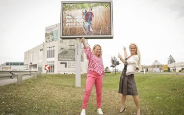Karin Sobotka, Leiterin Digital Marketing Raiffeisenlandesbank NÖ-Wien (links) und Claudia Mohr-Stradner, Director Sales Epamedia, vor einem digitalen Posterlight. (Foto: EPAMEDIA)