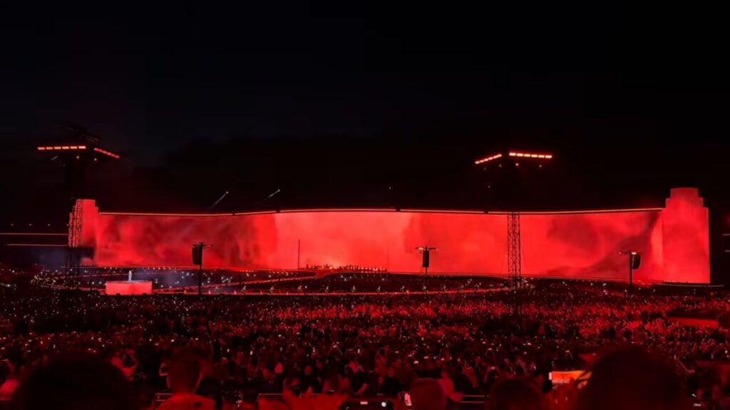 Während Adele auf einem Podium singt, läuft auf dem Megascreen im Hintergrund eine maßgeschneiderte Videoshow ab. (Foto: Screenshot/ In Concert)