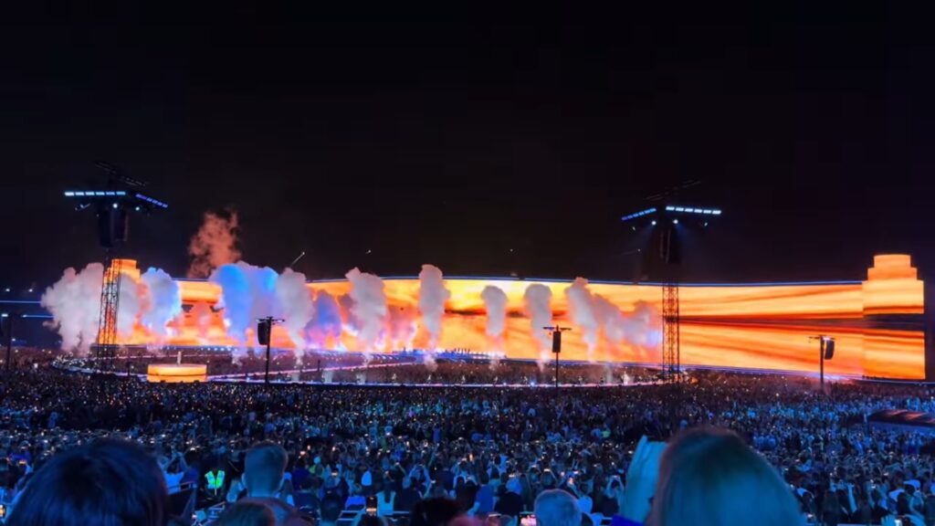 Während Adele auf einem Podium singt, läuft auf dem Megascreen im Hintergrund eine maßgeschneiderte Videoshow ab. (Foto: Screenshot/ In Concert)