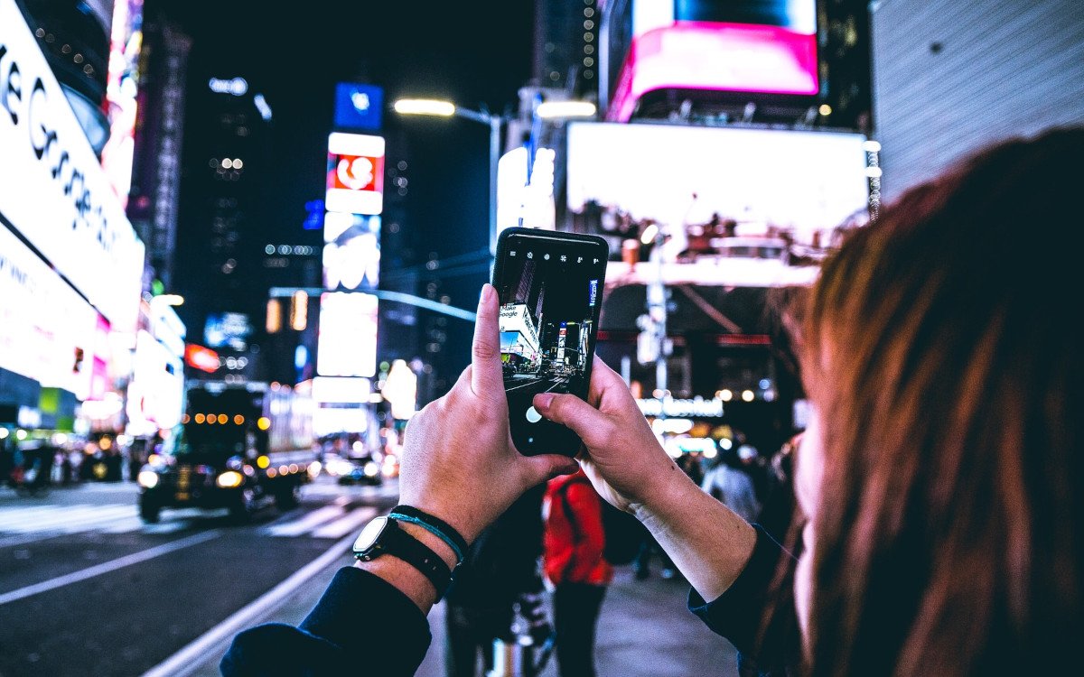 Junge Frau fotografiert Außenwerbung (Symbolbild; Foto: Rafael Leao/Unsplash)