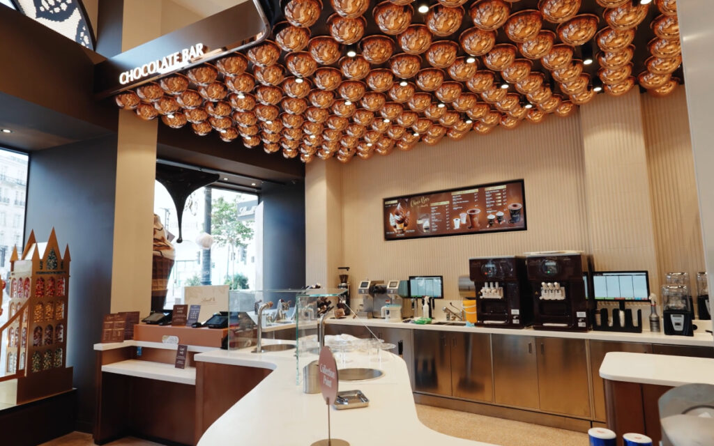 Ein Screen hinter der Food-Bar zeigt das gastronomische Angebot im Store. (Foto: First Impression)