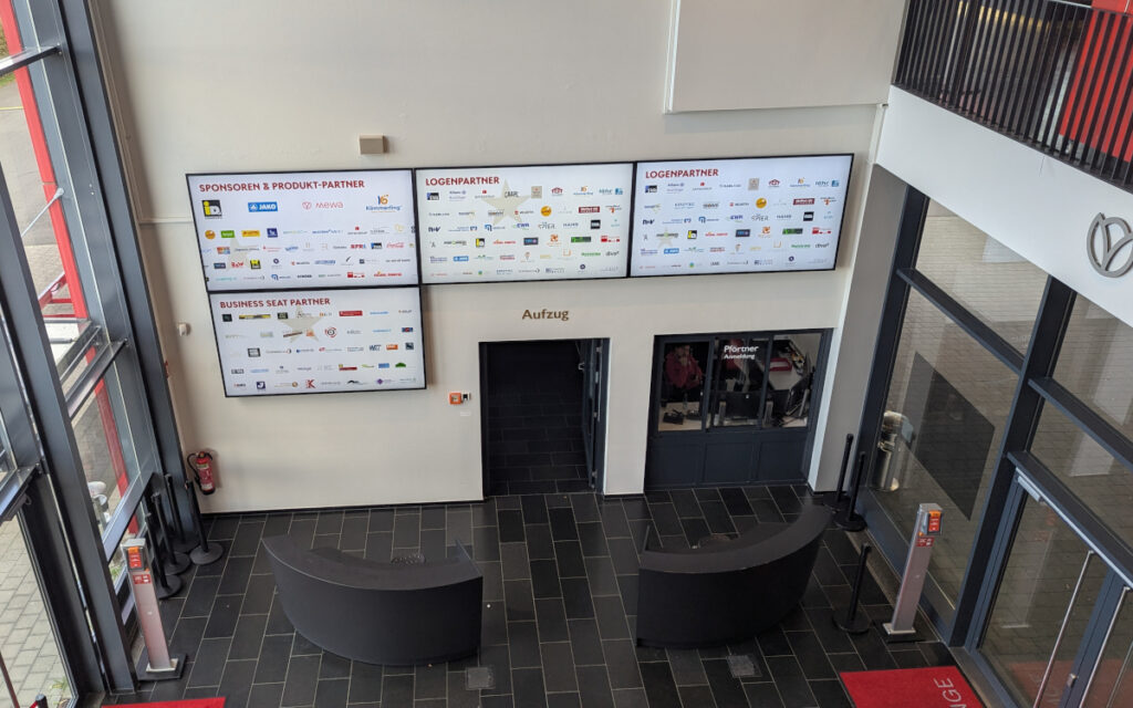 Die Screens im Eingangsbereich sind Sponsorenrückwände im Einsatz. (Foto: invidis)
