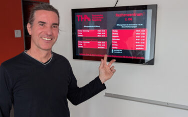 Jürgen Werner, Chief Business Development Officer bei Gekartel, vor einem kürzlich installierten Brandschutzdisplay in der TH Augsburg. (Foto: gekartel AG)