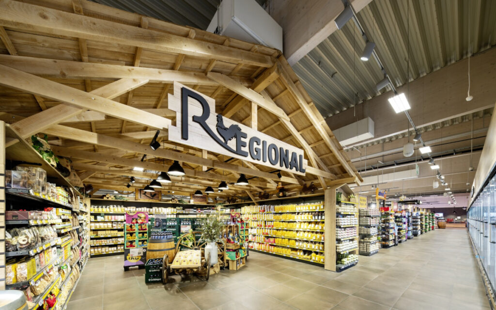 Eine hölzerne Installation zeigt das regionale Angebot im neuen Rewe-Markt in Baienfurt. (Foto: umdasch The Store Makers)