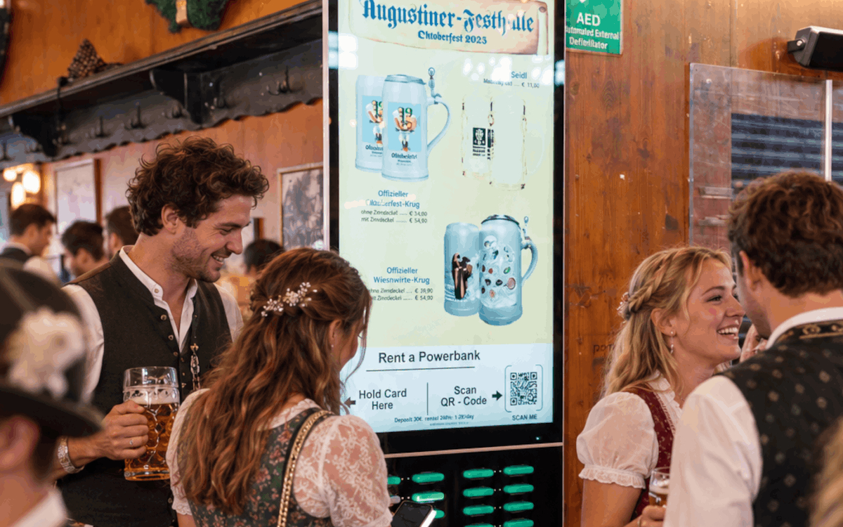 Der Screen ist echt, die Menge künstlich: So stellt sich AI die Rechargy-Stele auf der Wiesn bei vollem Festzelt vor. (Foto: KI/Rechargy)